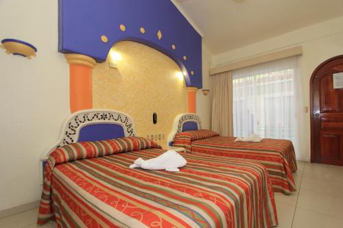 Habitación de hotel con 2 camas de color rojo y azul en Hotel Xestal, en Santa Cruz Huatulco