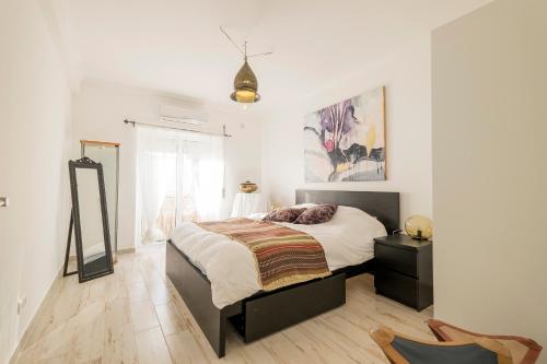 a bedroom with a bed and a mirror in it at Tavira Apartment in Tavira