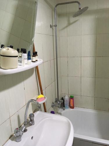 La salle de bains est pourvue d'un lavabo, d'une douche et d'une baignoire. dans l'établissement Two-Bedroom Apartment at Al Rehab, au Caire