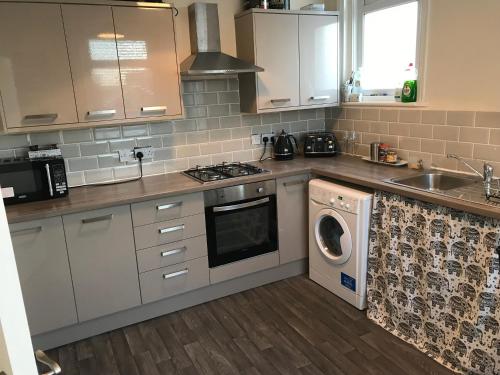 a kitchen with a sink and a washing machine at Blackpool Home with Tower View in Blackpool