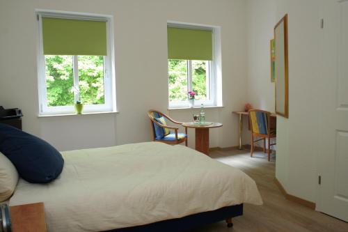 アルフにあるWald Villa Üssbachのベッドルーム1室(ベッド1台、テーブル、窓2つ付)