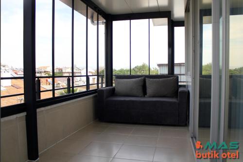 a couch sitting in a room with windows at Mas Butik Otel in Edremit