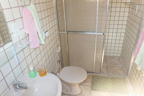 a bathroom with a shower and a toilet and a sink at Pousada Dona Felicidade in Cunha