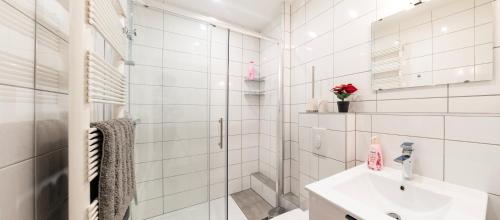 une salle de bain blanche avec un lavabo et une douche dans l'établissement CityCosy Strasbourg - Studio Hirtz Orangerie, à Strasbourg