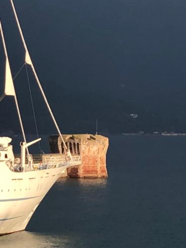a boat sitting in the water next to a rock in the water at Hotel Acquamarina in Portoferraio