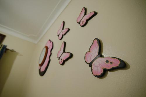 a group of pink butterflies on a wall at Lake Victoria Country Home in Entebbe