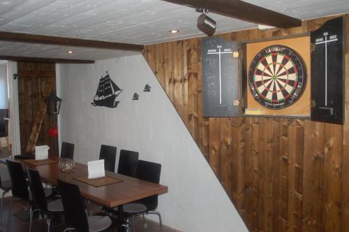 a dining room with a dartboard and tables and chairs at Gamla Bryggeriet Bed & Breakfast in Köpingsvik