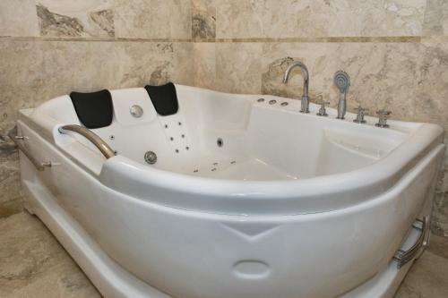 a white bath tub sitting next to a stone wall at Relais Dei Mercanti B&B And Suites in Pisa