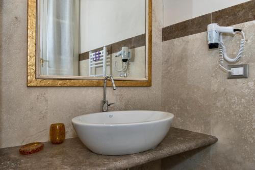 a bathroom with a white sink and a mirror at Relais Dei Mercanti B&B And Suites in Pisa