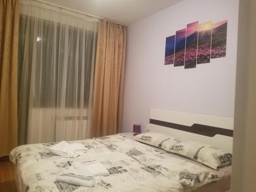 een slaapkamer met een bed en een schilderij aan de muur bij Belveder Holiday Club Private in Bansko