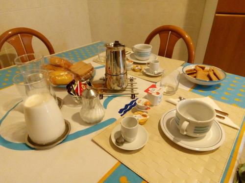 a table with plates and cups and milk on it at B&B SAN PIO in Pellezzano