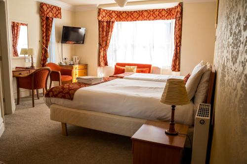 a hotel room with a bed and a desk at Farnley Tower Guesthouse in Durham