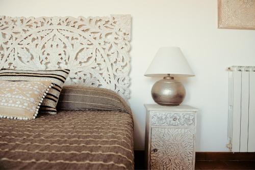 a bedroom with a bed and a lamp on a night stand at The Bell Tower Lodge in Palidoro
