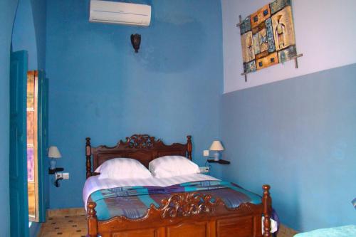 a bedroom with blue walls and a bed with white pillows at Riad Menthe Et Citron in Meknès