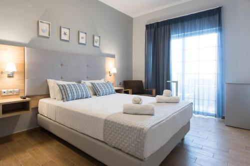 a bedroom with a large bed with towels on it at Georgioupolis Beach Hotel in Georgioupolis