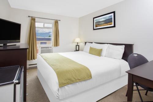 een hotelkamer met een bed, een bureau en een televisie bij Barriere Motor Inn-BMI in Barrière
