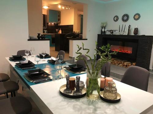 uma sala de jantar com uma mesa com cadeiras e uma lareira em Pilot's Manor - Airport Villa em Velika Gorica