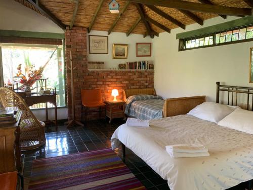 a bedroom with two beds and a table and a window at La Trini in Choachí