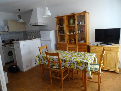cocina con mesa y sillas y TV en Appartement cap d'Agde 2 pièces - 4 personnes, en Cap d'Agde