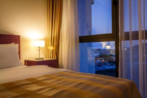 a hotel room with a bed and a large window at Luxury Budva Center Apartments in Budva