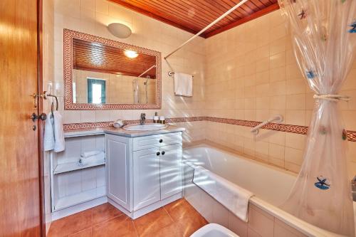 a bathroom with a tub and a sink and a bath tub at Música Penthouse 360º in Sesimbra