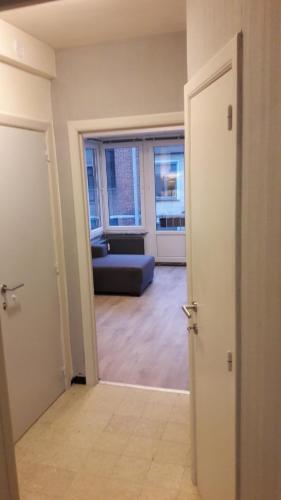 eine offene Tür zu einem Wohnzimmer mit einem Sofa in der Unterkunft Arno's Place in Ostende