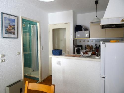 une cuisine avec un réfrigérateur blanc et un plan de travail dans l'établissement Appartement cap d'Agde 2 pièces - 4 personnes, au Cap d'Agde