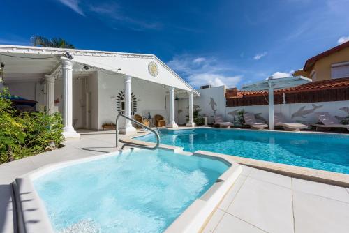 a swimming pool with a pool table and chairs at Sunflower Villa Studios in Palm-Eagle Beach
