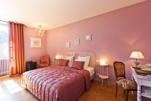 a hotel room with a bed and a desk at Hotel-restaurant Les Caudalies in Arbois