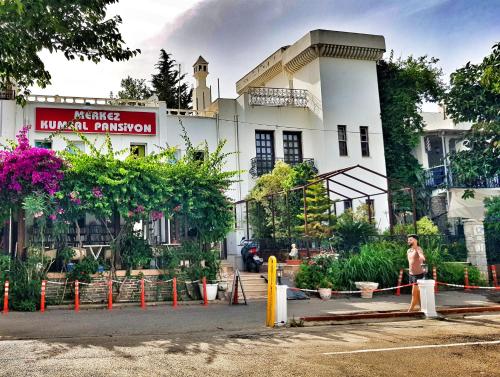 a man is standing in front of a building at Merkez Kumsal Pansiyon in Bodrum City