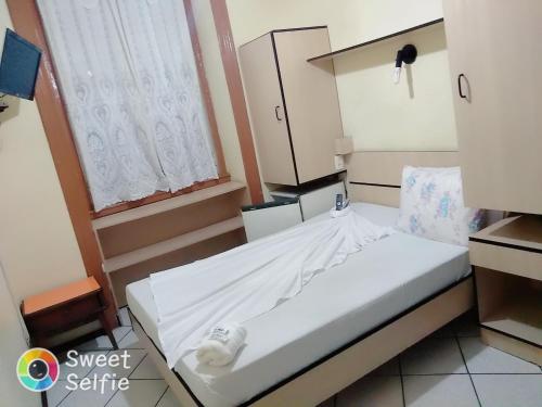 a small bed in a room with a window at Hotel Central Rosário in Jundiaí