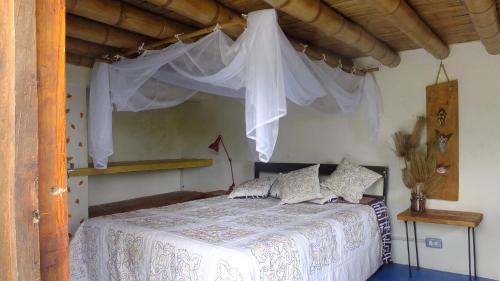 a bedroom with a bed with a white canopy at Soñarte Reserva Natural in Córdoba