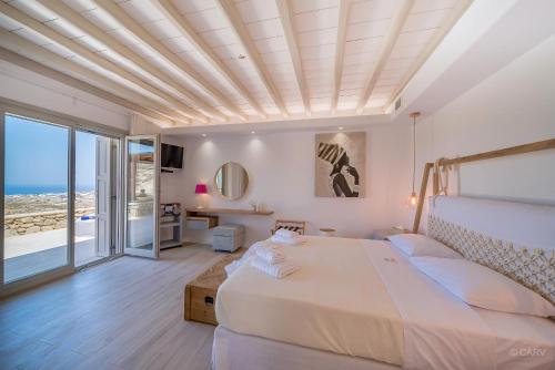 a bedroom with a large bed with a ceiling at Hyperion Villa by LLB Mykonos in Klouvas