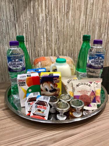 una bandeja de comida y bebida y botellas de agua en exploreNESS Apartment, en Inverness