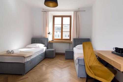 a bedroom with two beds and a desk and a table at Dom Architekta in Kazimierz Dolny