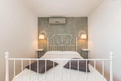 a bedroom with a white bed and a wall at Luxury 1 Bedroom Apartment in Rabac in Rabac