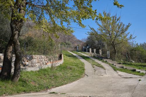 a dirt road next to a fence and trees at Villa Olga in Radanovići
