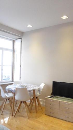 a dining room with a table and chairs and a television at The Porto Way in Porto