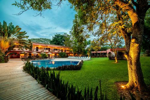 un complejo con piscina y un árbol en Hotel Chichen Itza, en Chichén Itzá