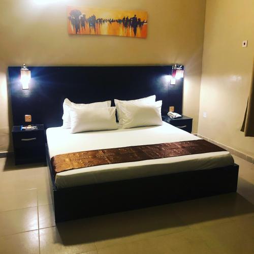 a bedroom with a large bed with white sheets and pillows at Posh Apartments Business Hotel in Ikeja