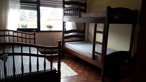 two bunk beds in a room with a window at apto centro de gramado in Gramado