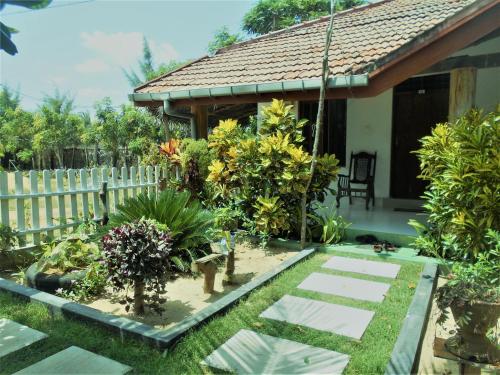 a garden in front of a house with plants at Shim Beach Resort in Arugam Bay