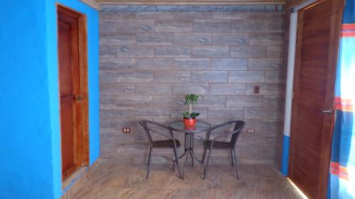 una mesa y sillas en una habitación con una pared de ladrillo en ZIRAHUÉN CUIN Habitaciones Rústicas, en Zirahuén