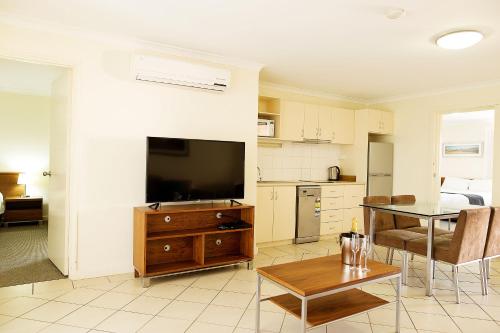 a kitchen with a table and chairs and a refrigerator at Kalbarri Edge Resort in Kalbarri