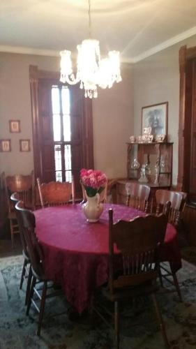 a dining room table with a vase of flowers on it at Smithville Historical Museum and Inn in Smithville