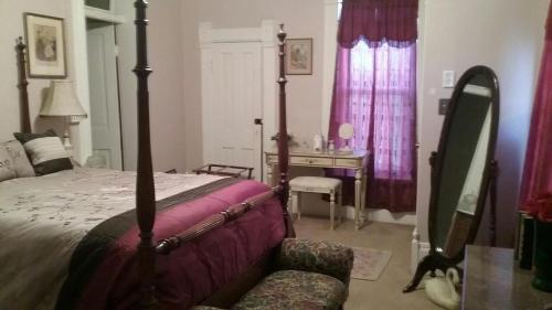 een slaapkamer met een bed, een tafel en een bureau bij Smithville Historical Museum and Inn in Smithville