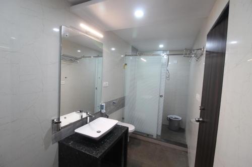 a bathroom with a sink and a mirror at Green Arc Homestay in Malvan