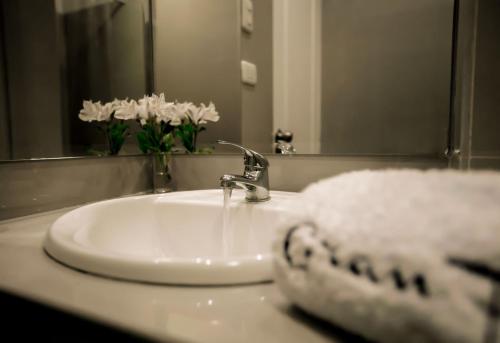 a bathroom sink with a white towel and a mirror at Hotel Gran Palma Piura in Piura