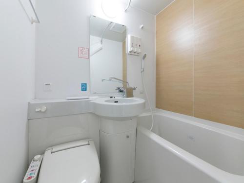 a white bathroom with a sink and a toilet at R&B Hotel Nagoya Shinkansenguchi in Nagoya