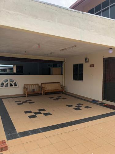 a room with a tile floor with a table and bench at New Casa De Monte in Melaka